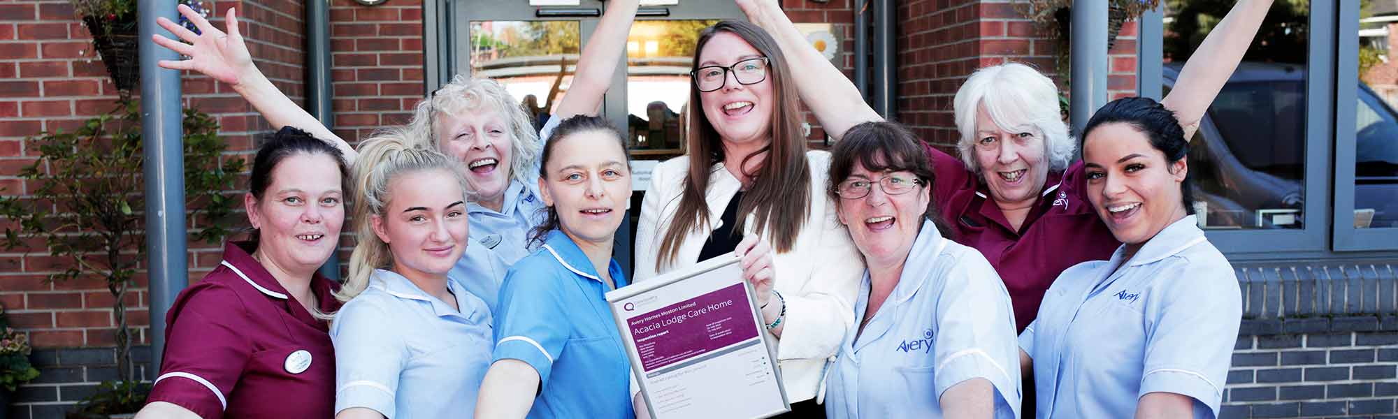 Joanna and team from Acacia Lodge celebrate CQC Outstanding banner hero