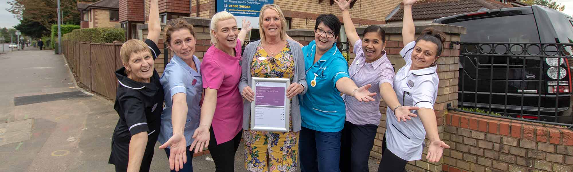 Angela Roughton and staff celebrate CQC GIAC banner hero